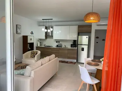 a living room and kitchen with a couch and a table at Estrella Dominicus - Excepcional Apartamento en el Caribe in Bayahibe