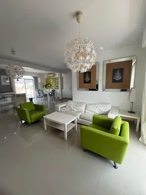 a living room with green furniture and a chandelier at bello PH cerca de la playa in Punta Cana