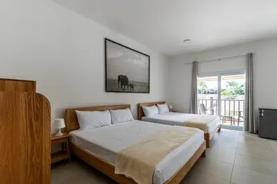 a hotel room with two beds and a balcony at Parque Acuático - Sosua! in Laguna del Higüero