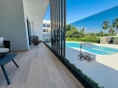 a living room with a view of a swimming pool at New pool views Sausalito Residencial close to Playa Bavaro in Punta Cana
