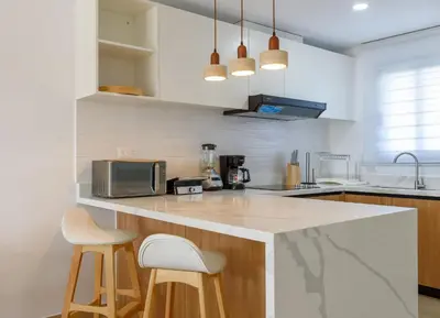a kitchen with a counter and two stools at New pool views Sausalito Residencial close to Playa Bavaro in Punta Cana