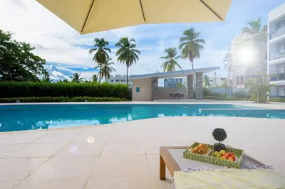 a bowl of fruit sitting on a bench next to a swimming pool at New pool views Sausalito Residencial close to Playa Bavaro in Punta Cana