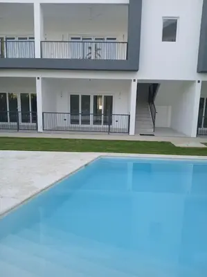 a building with a swimming pool in front of it at En Plaza Center Penthouse con 3 terrazas en el centro de Las Terrenas la playa està a 5 min a pied in Las Terrenas