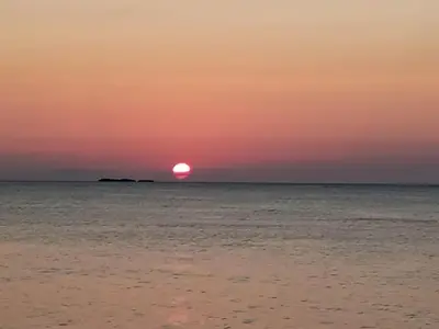 a sunset over the ocean with the sun setting at En Plaza Center Penthouse con 3 terrazas en el centro de Las Terrenas la playa està a 5 min a pied in Las Terrenas