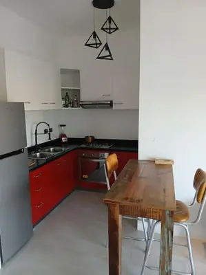 a kitchen with a wooden table and a refrigerator at En Plaza Center Penthouse con 3 terrazas en el centro de Las Terrenas la playa està a 5 min a pied in Las Terrenas