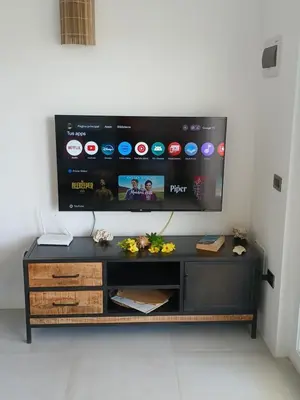 a black entertainment center with a tv on a wall at En Plaza Center Penthouse con 3 terrazas en el centro de Las Terrenas la playa està a 5 min a pied in Las Terrenas