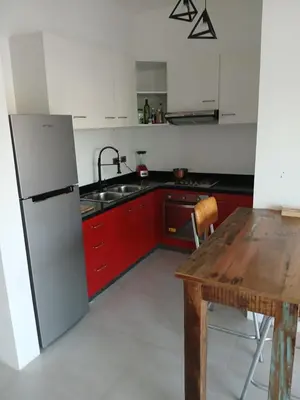 a kitchen with a wooden table and a refrigerator at En Plaza Center Penthouse con 3 terrazas en el centro de Las Terrenas la playa està a 5 min a pied in Las Terrenas