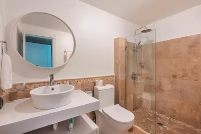 a bathroom with a sink and a mirror and a toilet at Magnificent villa with ocean view in Puerto Bahia in Sabana