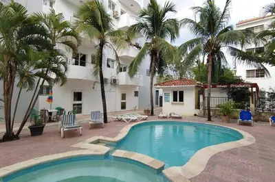a pool in front of a hotel with palm trees at Juan Dolio,Beach, Pool, 40