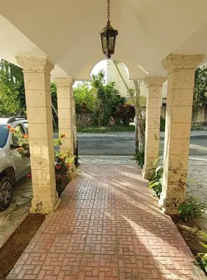 a brick walkway with a car parked under a building at Juan Dolio,Beach, Pool, 40