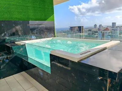 a pool on the roof of a building at Luxury penthouse con jacuzzi privado, Gym, pool in Santo Domingo