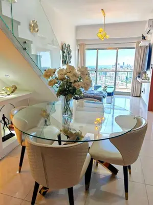 a dining room with a glass table and chairs at Luxury penthouse con jacuzzi privado, Gym, pool in Santo Domingo
