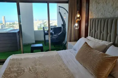 a bedroom with a bed with a view of a balcony at Luxury penthouse con jacuzzi privado, Gym, pool in Santo Domingo