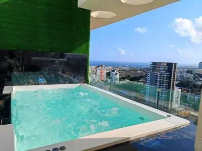 a swimming pool in a building with a large window at Luxury penthouse con jacuzzi privado, Gym, pool in Santo Domingo