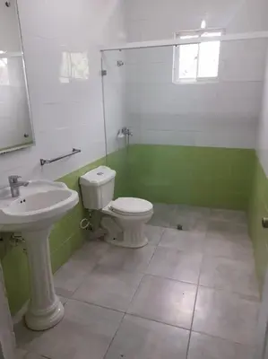 a green and white bathroom with a toilet and sink at Maison T4, près de la mer in La Romana
