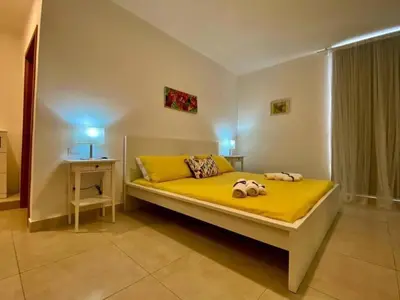 a bedroom with a yellow bed with two stuffed animals on it at apartamento luxury in La Laguna