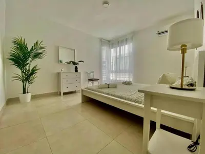 a bedroom with a bed and a table and a plant at apartamento luxury in La Laguna