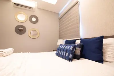 a bedroom with a large white bed with blue pillows at Exclusivo apartamento - Soha Suites II-B9 - 2 BR in Rincón Largo