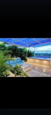 a view of a patio with blue chairs and a view of the ocean at Agréable appartement en rooftop in La Cabirma