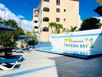 a swimming pool with lounge chairs and a building at Apartamento en la playa 1A - Residencial Marina Bay in Cuevas
