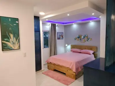 a bedroom with a bed with a purple lighting at Agréable appartement en rooftop in La Cabirma