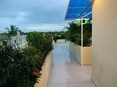 a balcony of a building with flowers and plants at Agréable appartement en rooftop in La Cabirma
