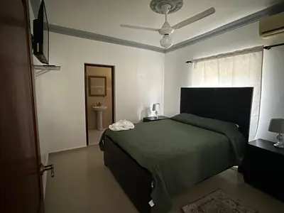 a bedroom with a green bed and a bathroom at Casa completa con hermosa vista in San Felipe de Puerto Plata