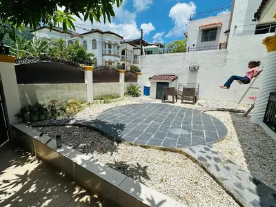 a girl is jumping off a wall in a backyard at Casa completa con hermosa vista in San Felipe de Puerto Plata