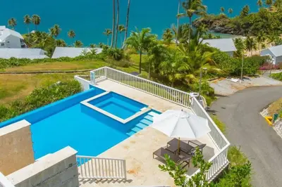 an overhead view of a swimming pool with an umbrella at Ocean Front Deluxe Condo in Punta Balandra