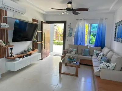 a living room with a couch and a flat screen tv at Timeless Luxury Villa-Ocean View 3BRM-5Bath-Pool in San Felipe de Puerto Plata