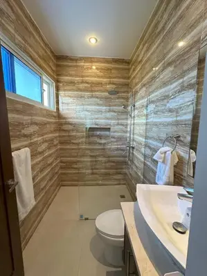 a bathroom with a shower and a toilet and a sink at Timeless Luxury Villa-Ocean View 3BRM-5Bath-Pool in San Felipe de Puerto Plata