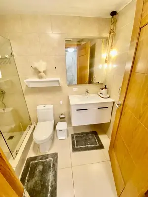 a bathroom with a toilet and a sink and a mirror at LasOlasTower JuanDolio-2Br-3Bds-7Px-WiFi-SeaView in Juan Dolio