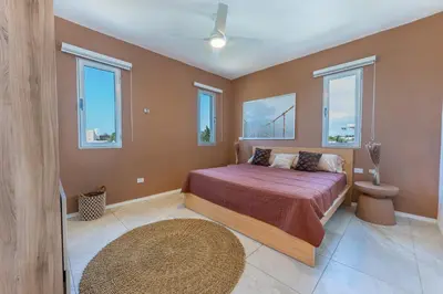 a bedroom with a bed and windows at Villa Chocolate in Laguna del Higüero
