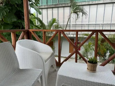 a balcony with two chairs and a table and a plant at Luz de Luna Emotions in Santo Domingo