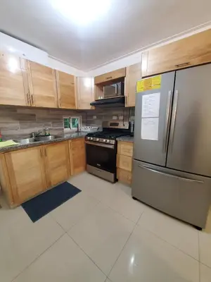 a kitchen with wooden cabinets and a stainless steel refrigerator at Lo mejor para descansar in Mendoza