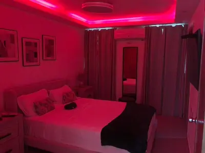a bedroom with a bed with a pink lighting at Lo mejor para descansar in Mendoza