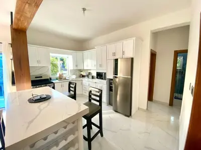 a kitchen with white cabinets and a stainless steel refrigerator at Fantástico apartamento céntrico Playa a 100 mts in Río San Juan