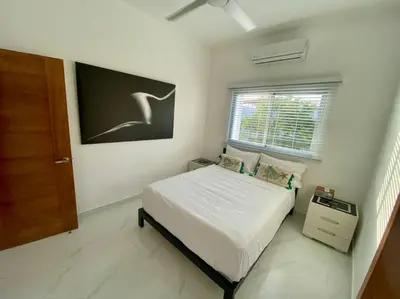 a bedroom with a bed and a window and a door at Fantástico apartamento céntrico Playa a 100 mts in Río San Juan