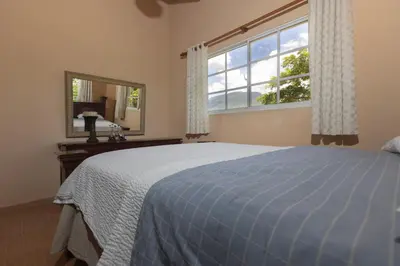 a bedroom with a blue bed and a window at Casa Palmar in Palmar Arriba