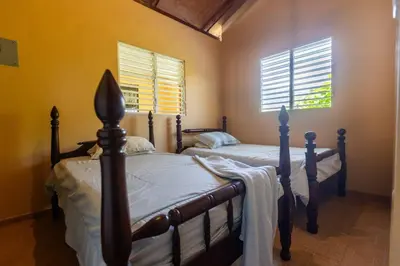 two beds in a bedroom with two windows at Casa Palmar - Finca in Palmar Arriba