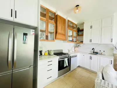 a kitchen with white cabinets and a stainless steel refrigerator at Victorian Condominio in Cabarete