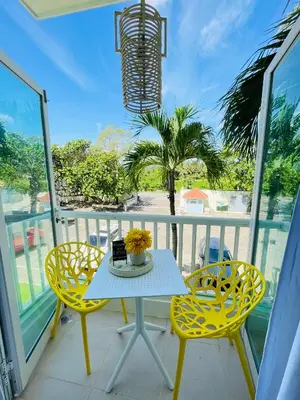 a balcony with a table and chairs and a palm tree at Victorian Condominio in Cabarete