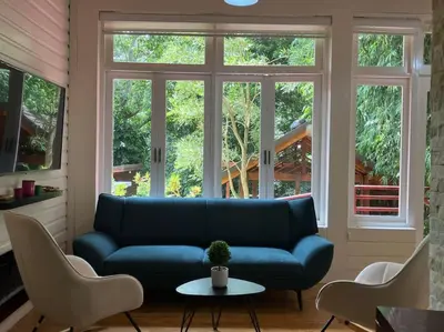 a living room with a blue couch and windows at Villa Reina in Buena Vista