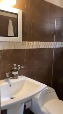 a bathroom with a sink and a toilet and a mirror at Villa Reina in Buena Vista