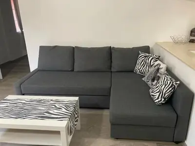 a gray couch with zebra pillows in a living room at Eden 07 08 in La Laguna