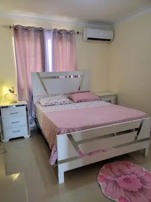 a bedroom with a bed with pink sheets and a window at Elegante apartamento en San isidro in Mendoza