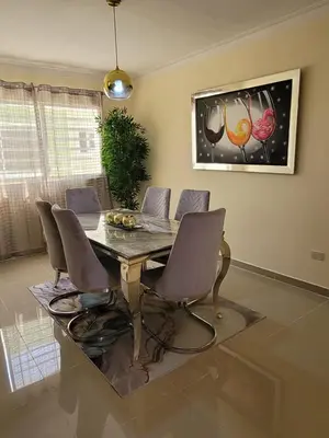 a dining room table with chairs and a painting on the wall at Elegante apartamento en San isidro in Mendoza