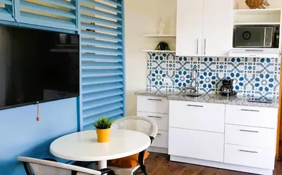 a kitchen with a white table and a blue wall at Cadaques Caribe Bayahibe Private beach in Bayahibe
