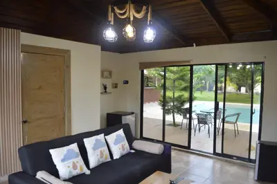 a living room with a couch and a view of a pool at Villa Doña Plinia in El Cruce