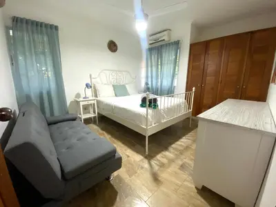 a bedroom with a bed and a chair and a crib at Beautiful Place in los Corales bavaro in Punta Cana
